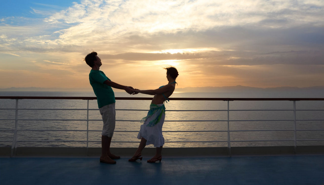 man with woman on deck of cruise ship at sunset