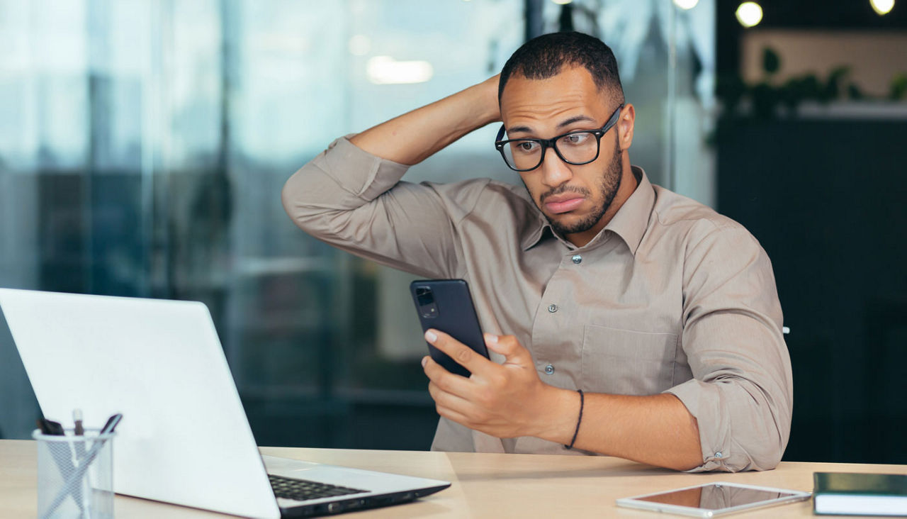 Businessman working with laptop and phone at an office conference table