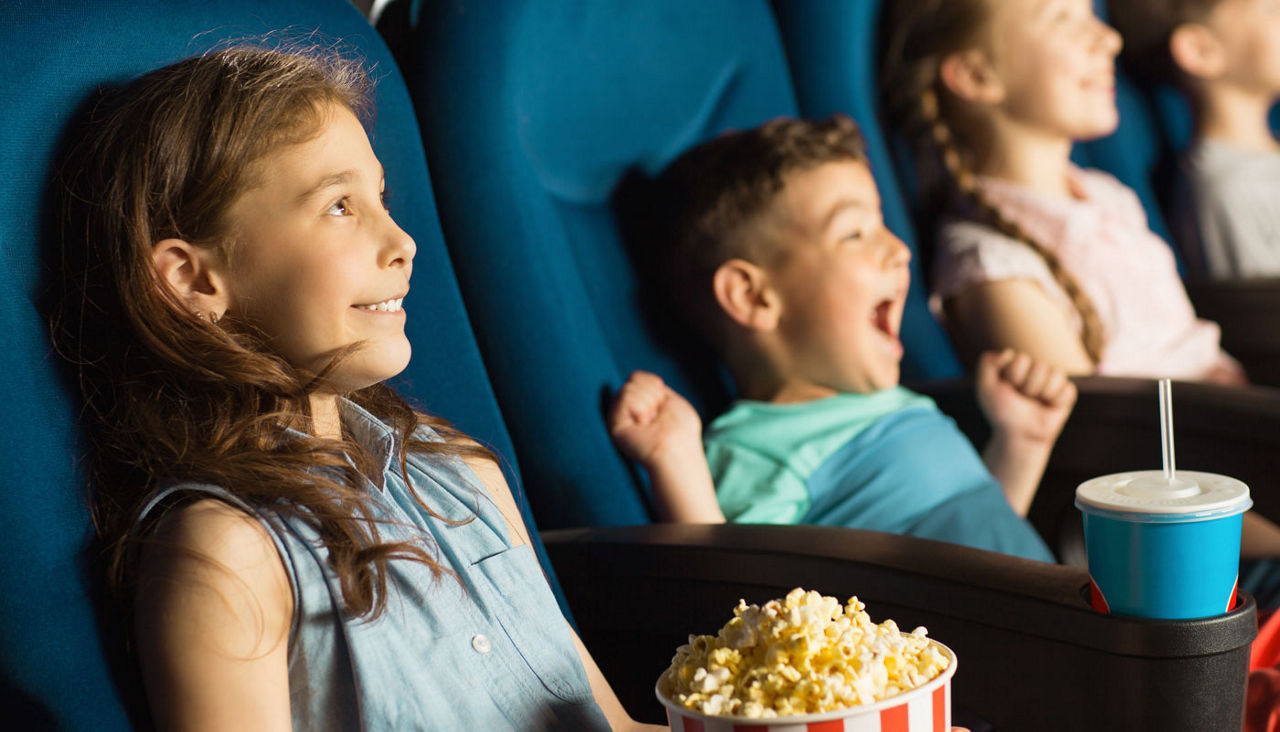 Group of happy kids enjoying a movie at the cinema