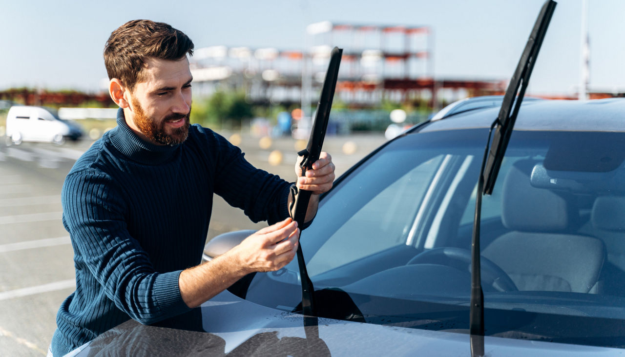 Man checking wiper blades on his car.