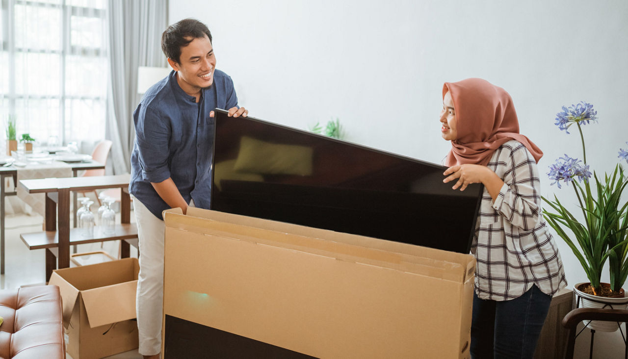 Excited Couple Setting Up New Television At Home