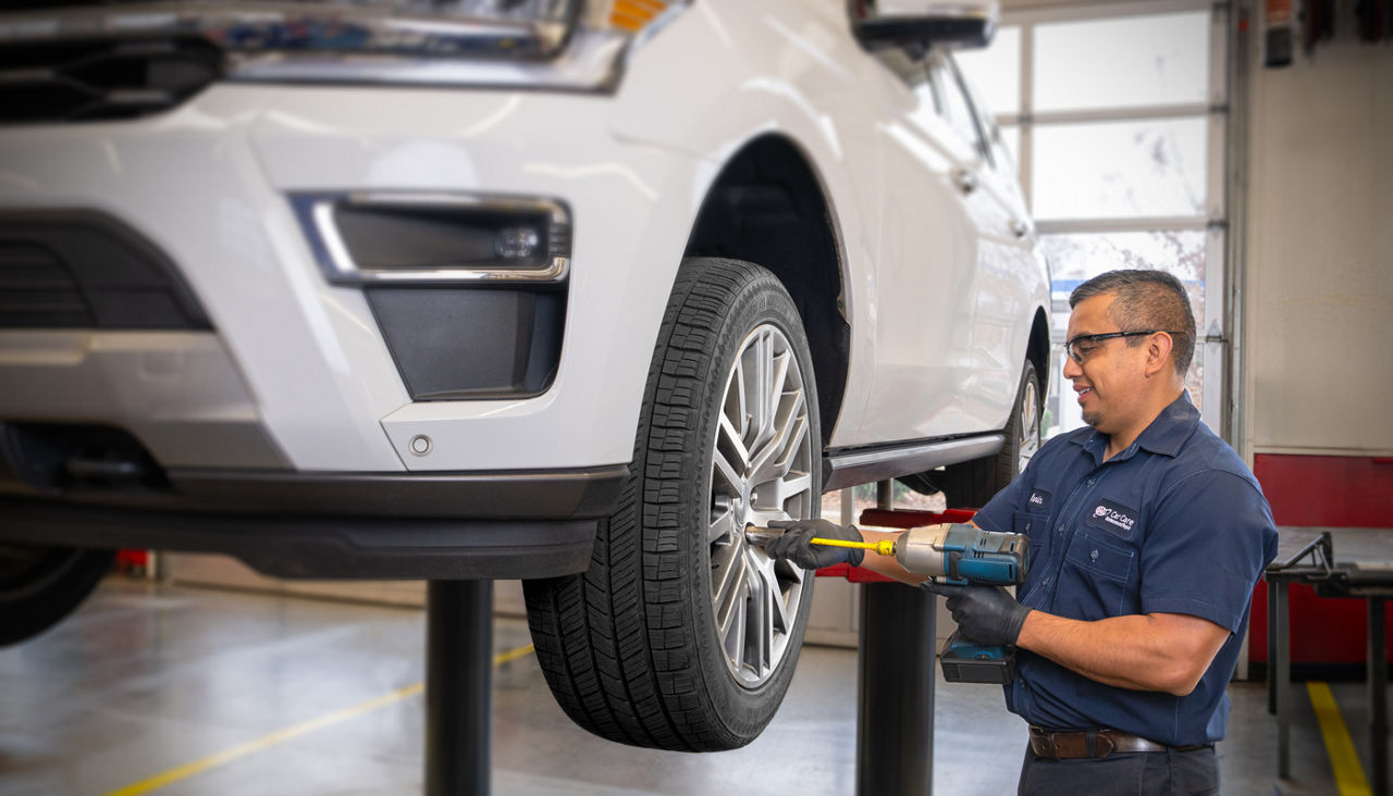 Service tech putting tire back on car after brake repair