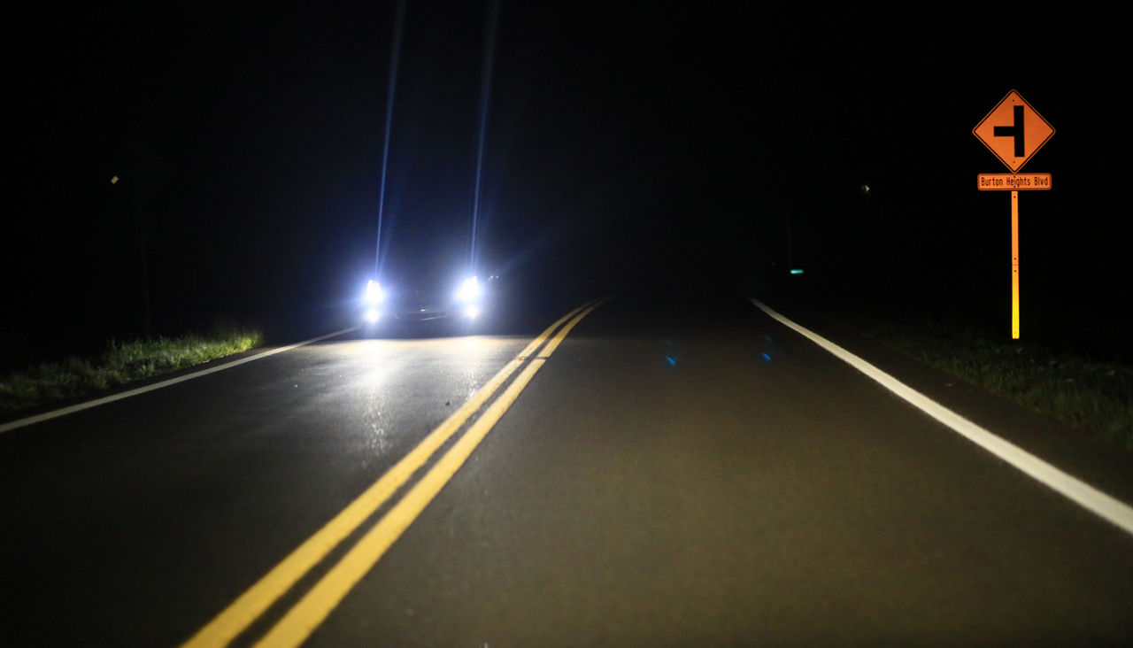 Car headlights on a dark road