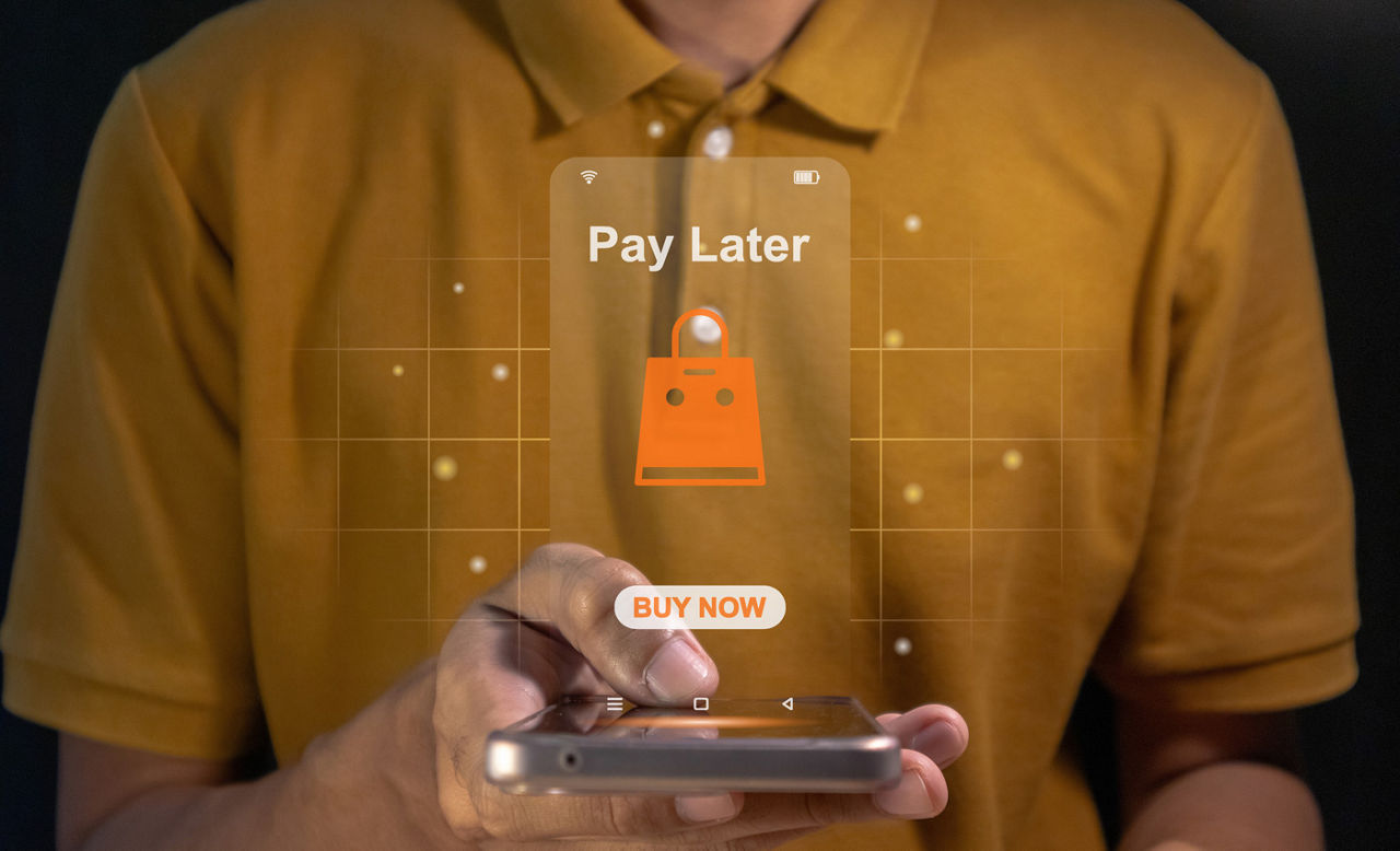 Man using a phone for online shopping with Buy Now Pay Later projecting above it