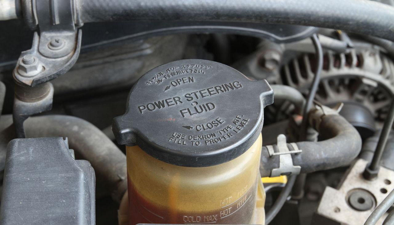 Power steering fluid cap with warning label in a car