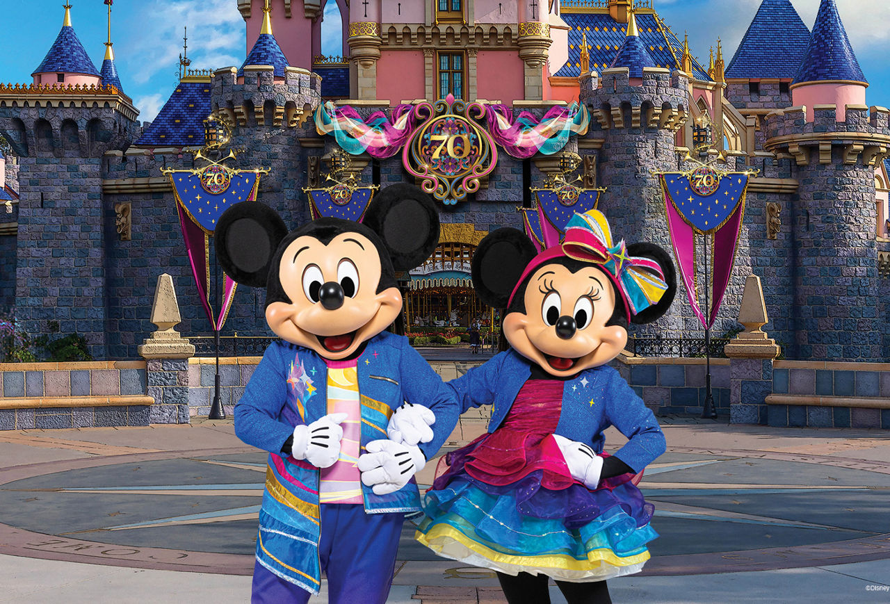 Mickey and Minnie in front of Sleeping Beauty Castle decorated in 70th Anniversary colors