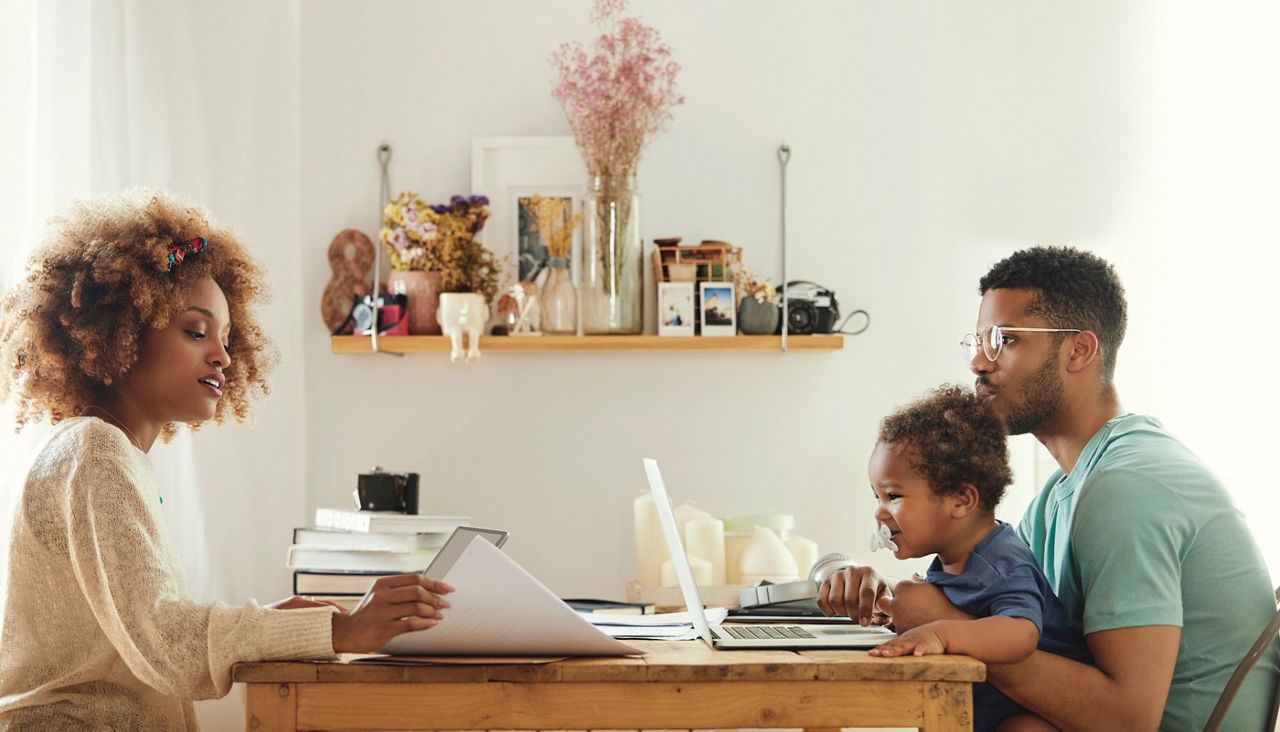 Parents using technology while sitting with son