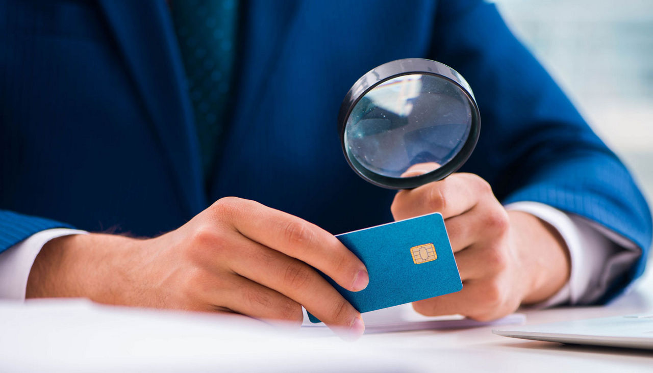 Man looking closer on the back of his credit card