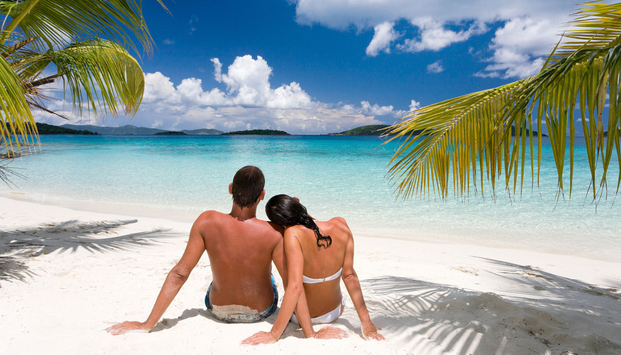Couple sitting in the sand on a Caribbean beach