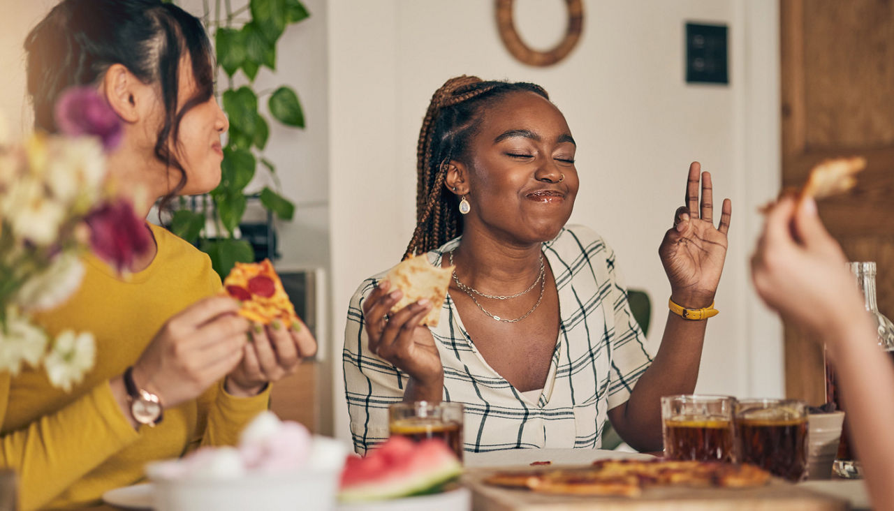 Friends enjoying pizza at a home party