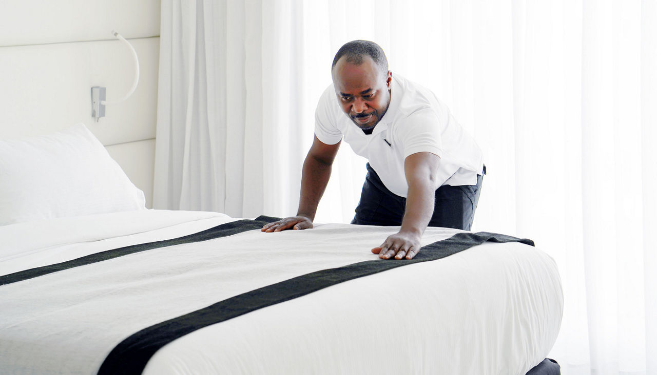 hotel staff making bed in hotel