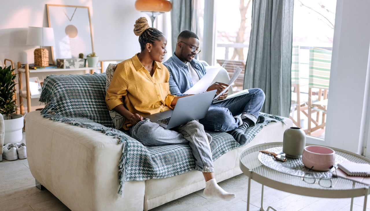 Young couple going over paperwork while sitting on the sofa