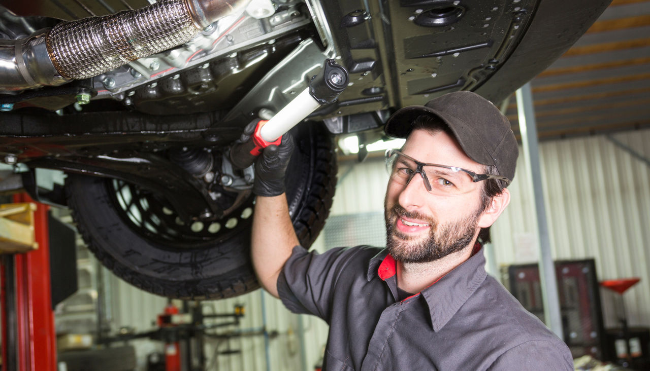 Mechanic working on car in his shop