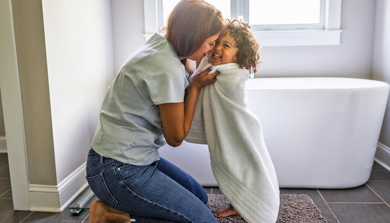 Mother drying toddler with towel after a bath