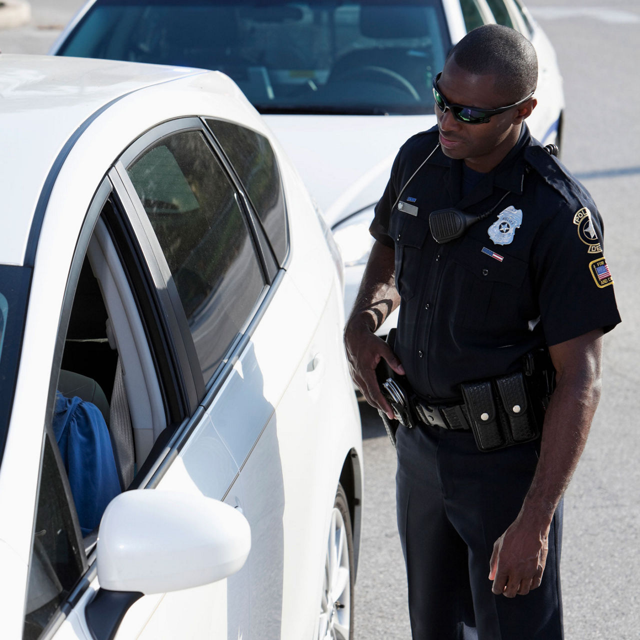Police officer pulling over driver with dark tinted windows