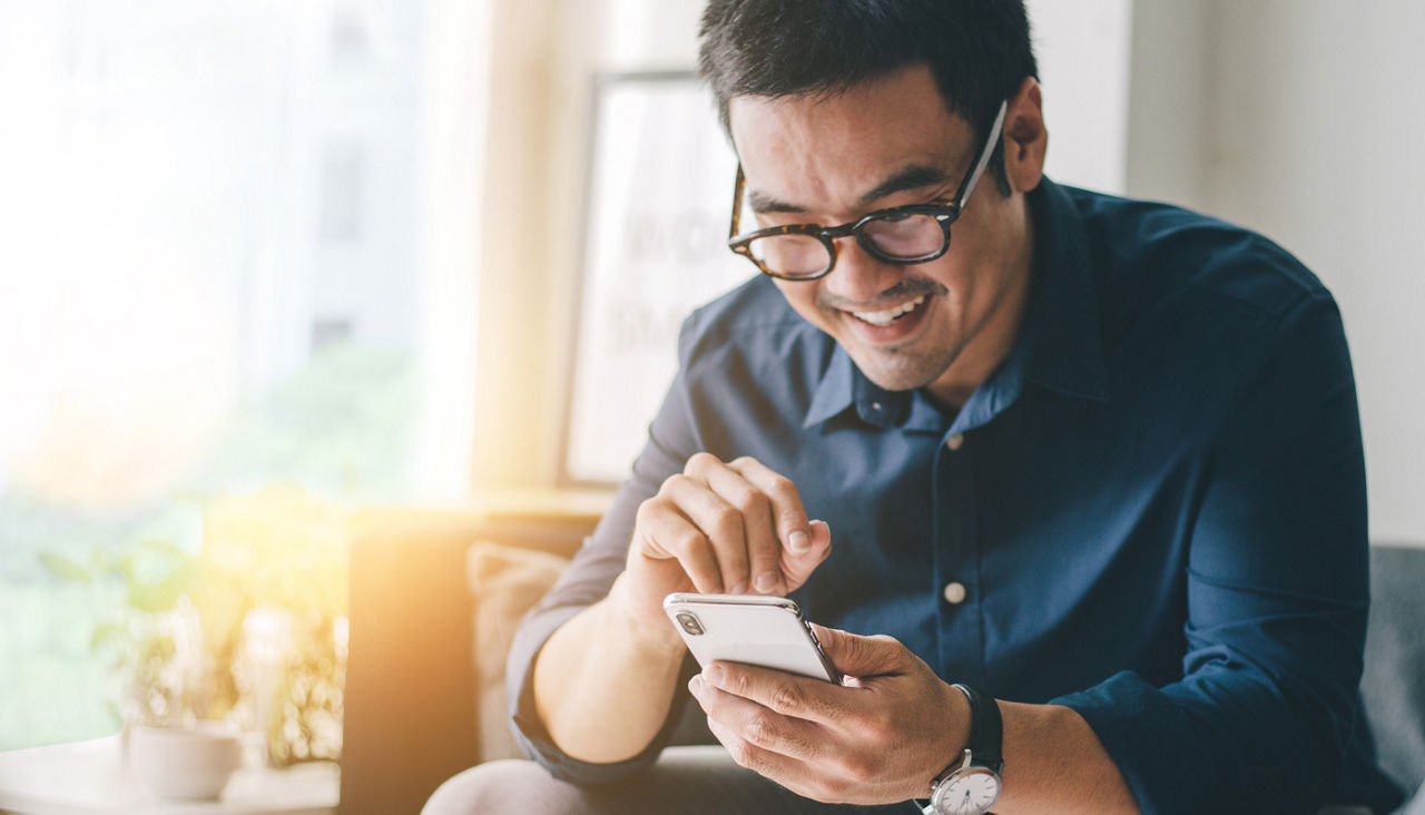 Man is viewing his mobile phone in home