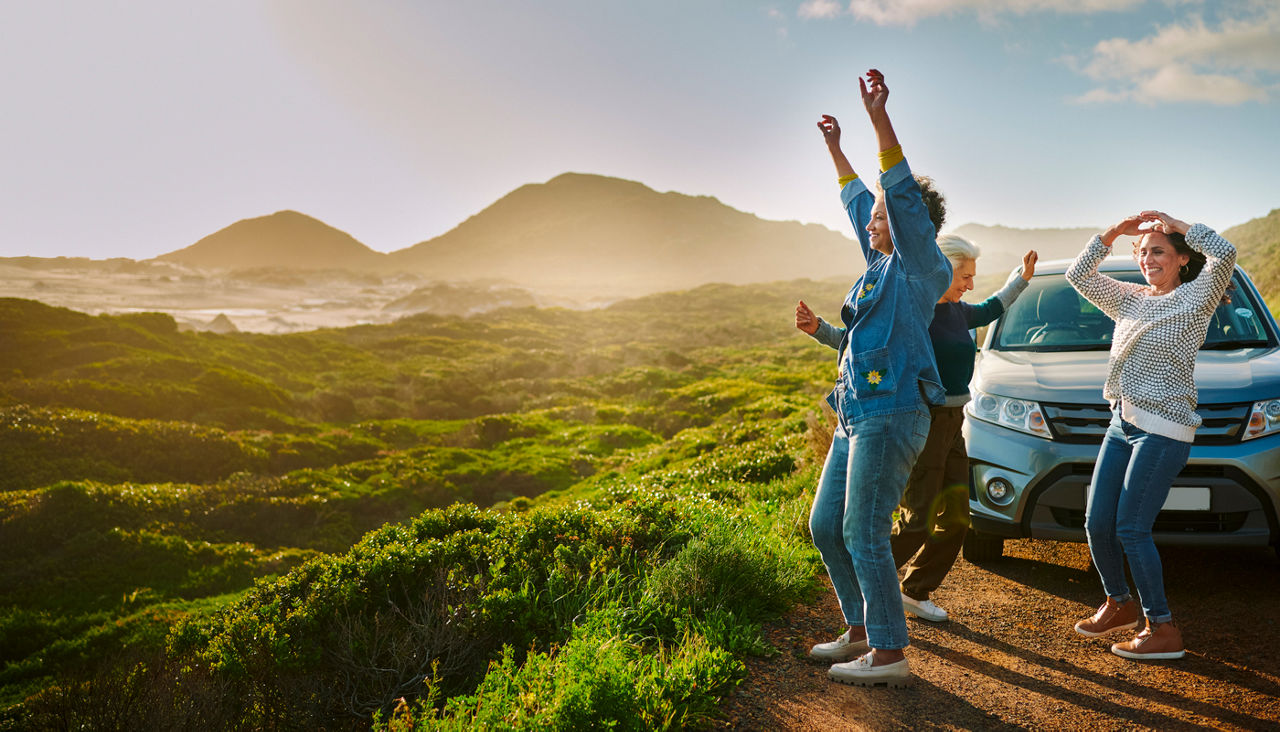 group of friends or amily celebrating on an off road adventure with mountains in background