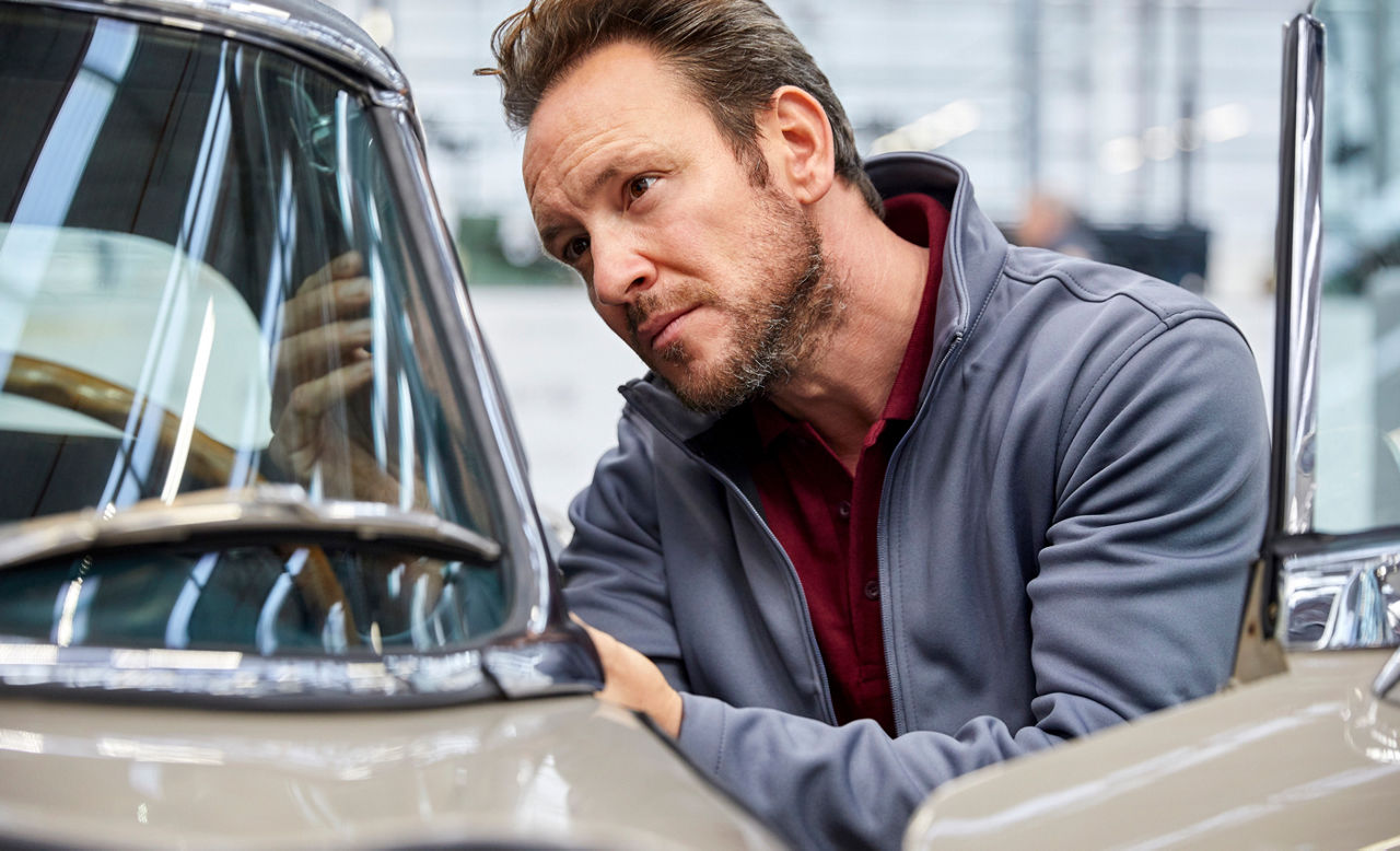 Male engineer examining vintage car in industry