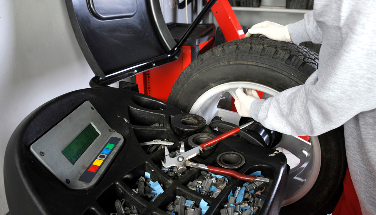 Mechanic performing a wheel balancing