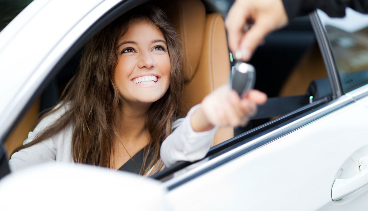 Woman receiving keys for a car