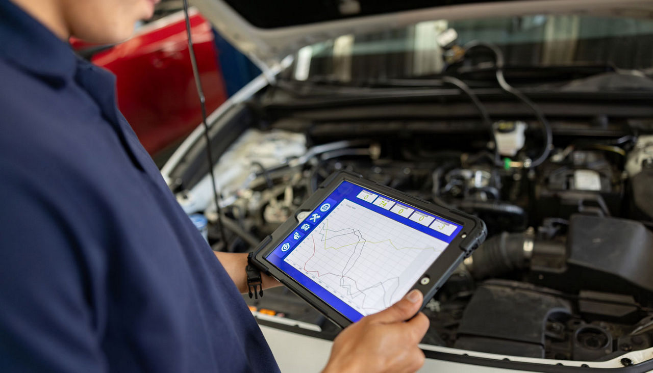 Mechanic using a scanner to diagnose a problem with a car at the garage