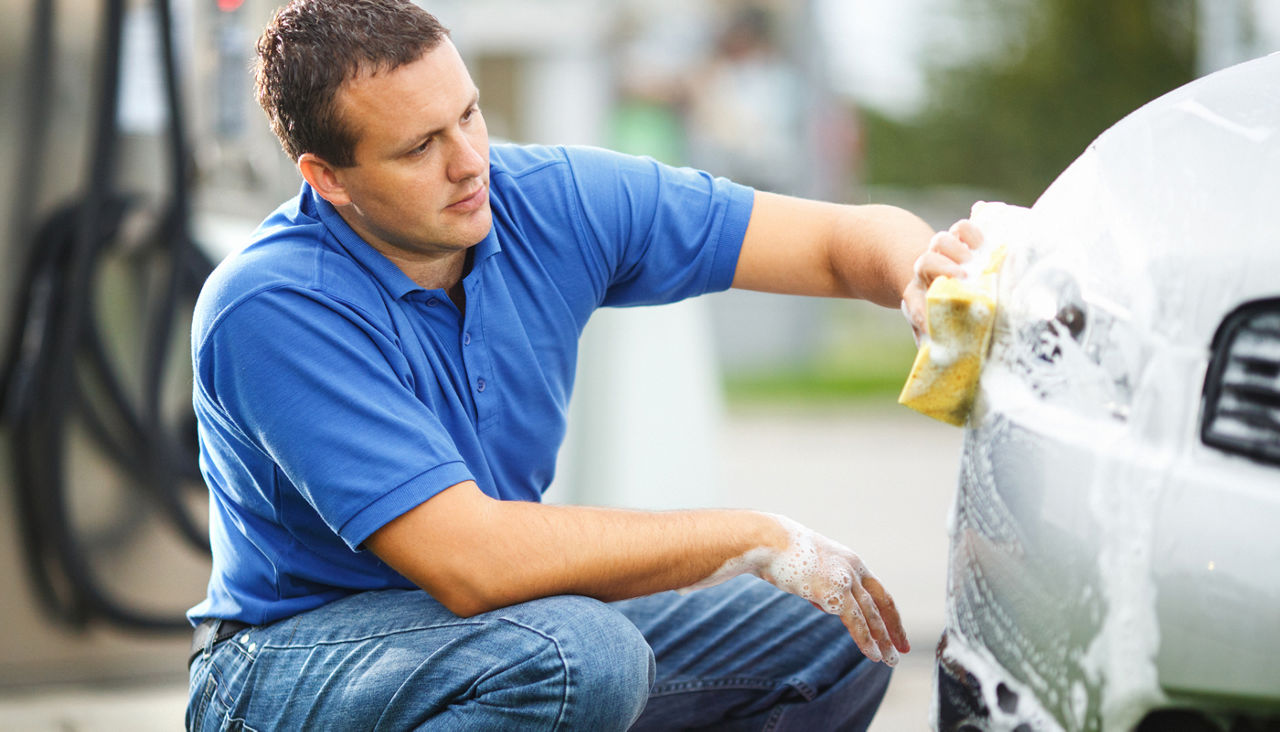 Man cleaning his car, headlights