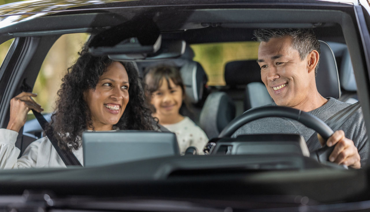 Cheerful family enjoying road trip in car