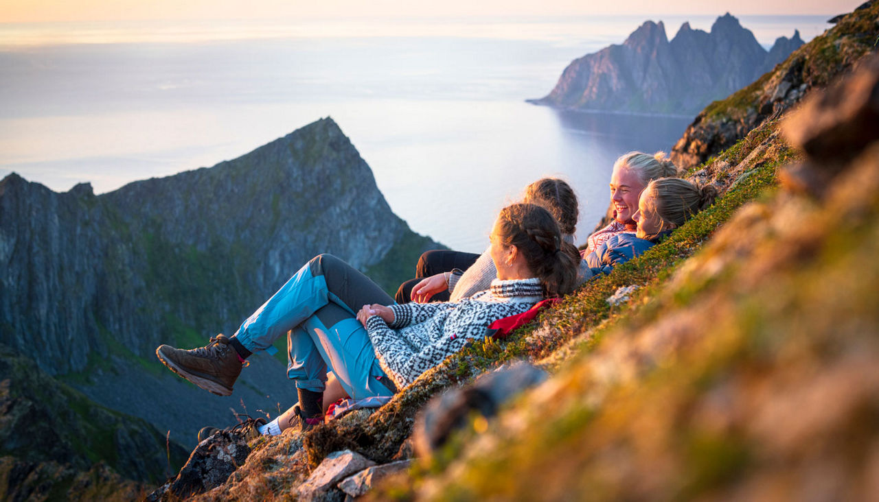 Girls enjoying sunset above the fjord, Senja, Norway