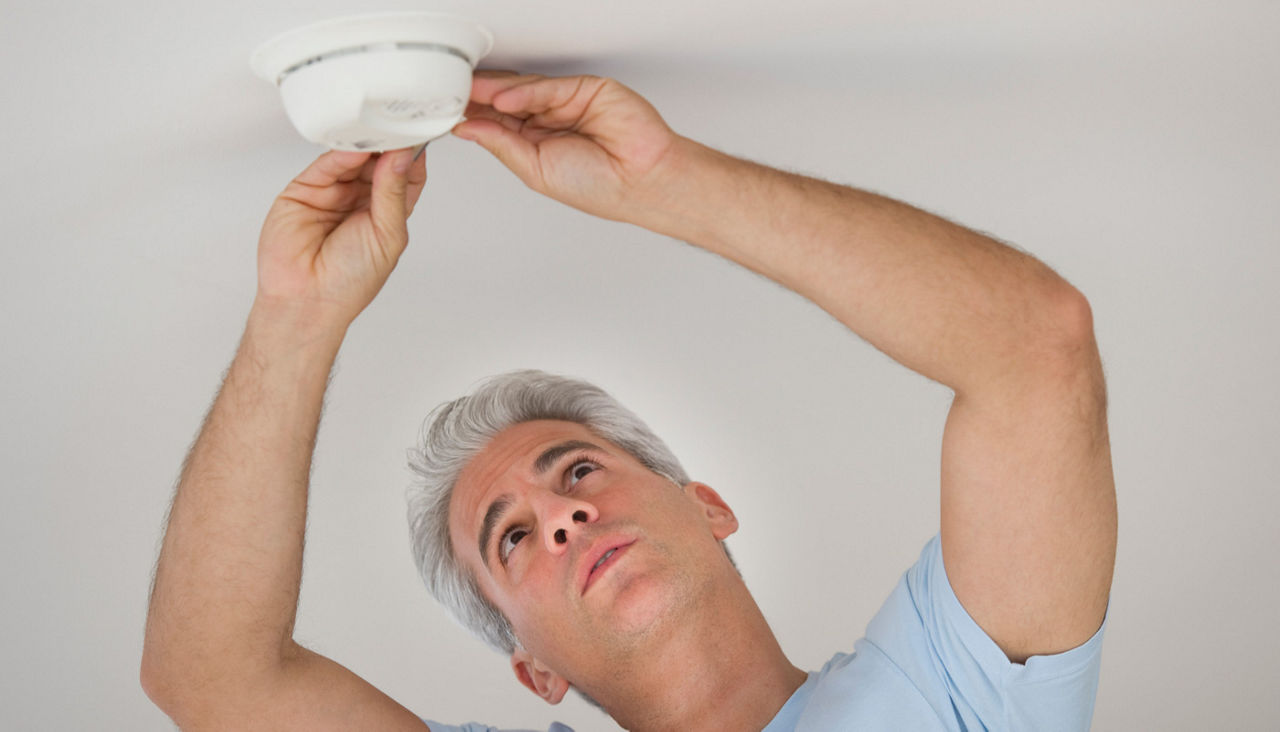Man testing smoke detector