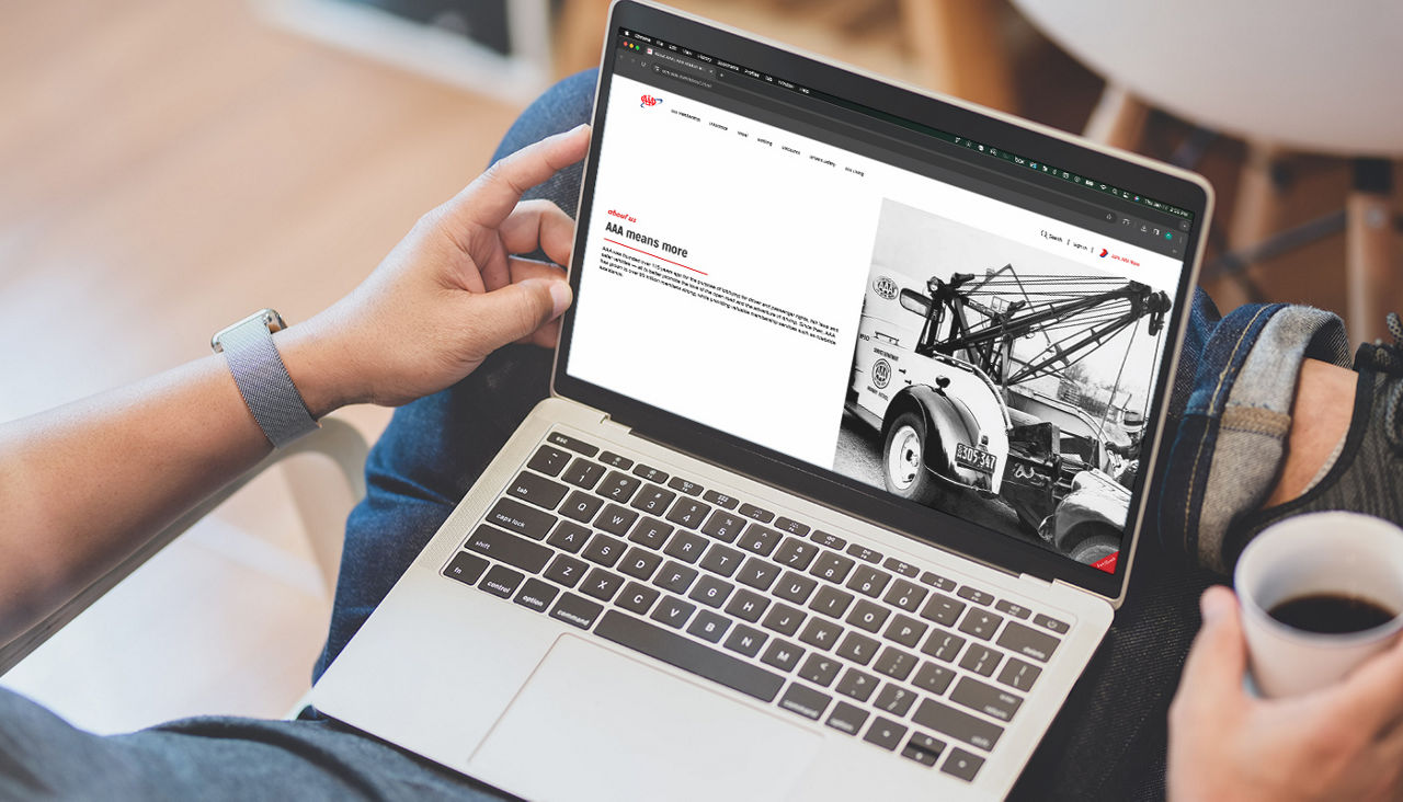 Over-the-shoulder view of a person browsing AAA’s website on their laptop.