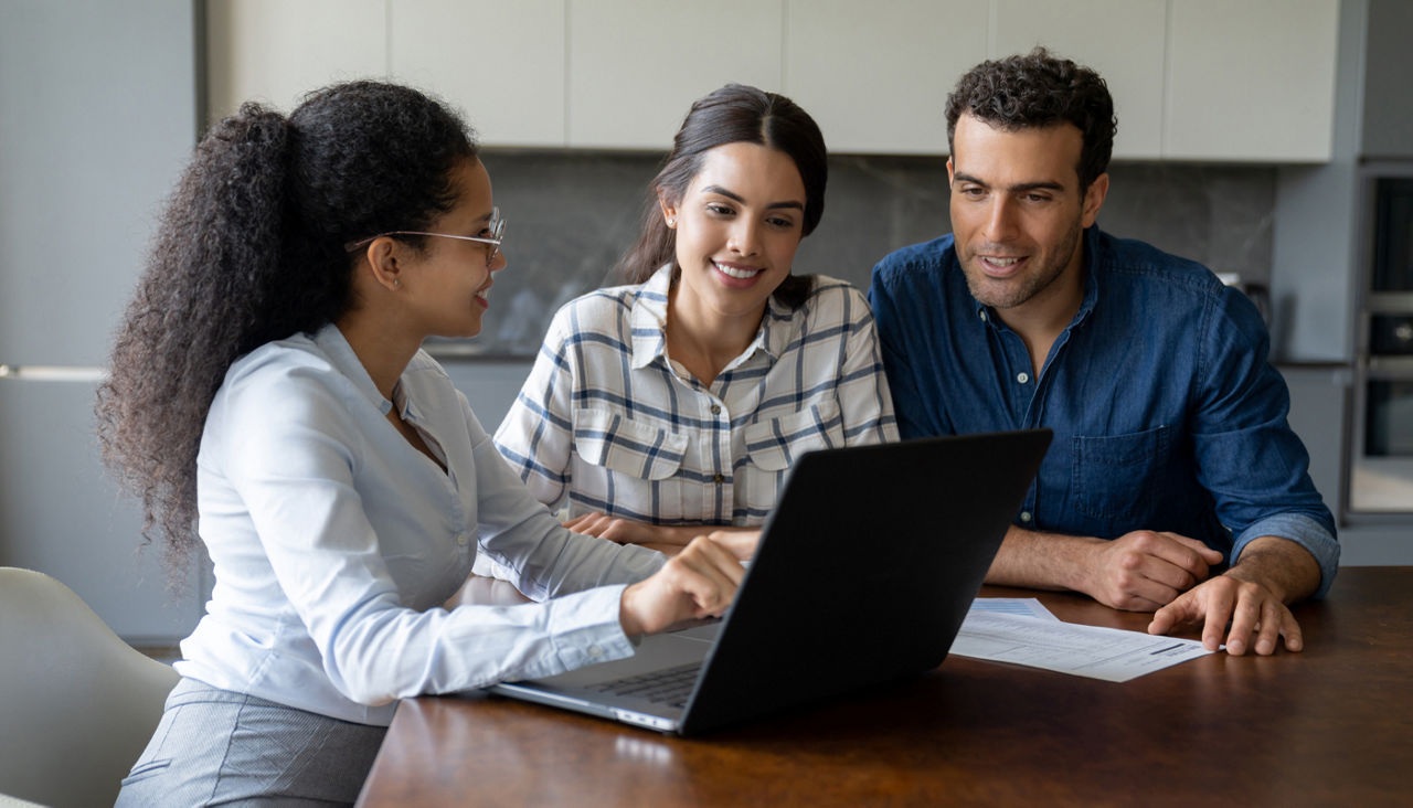 Couple talking to a financial advisor while looking at laptop on desk