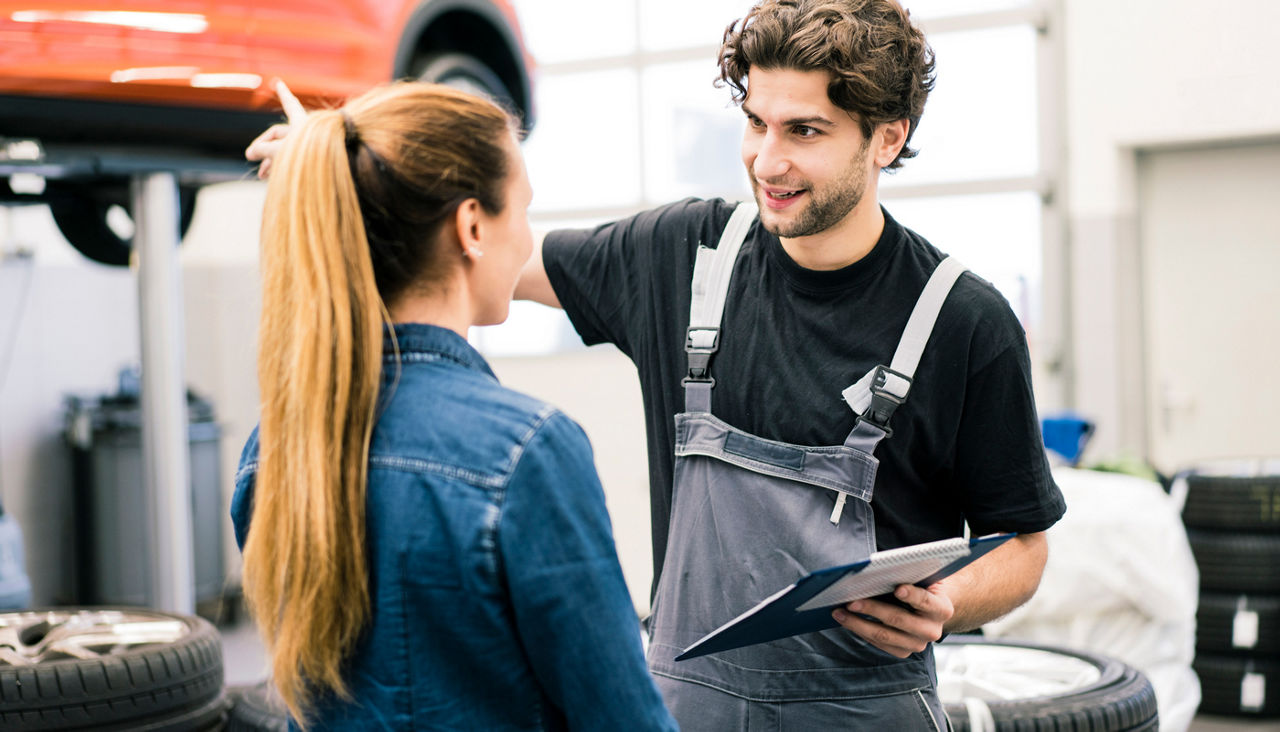 Auto mechanic discussing car repairs with a customer
