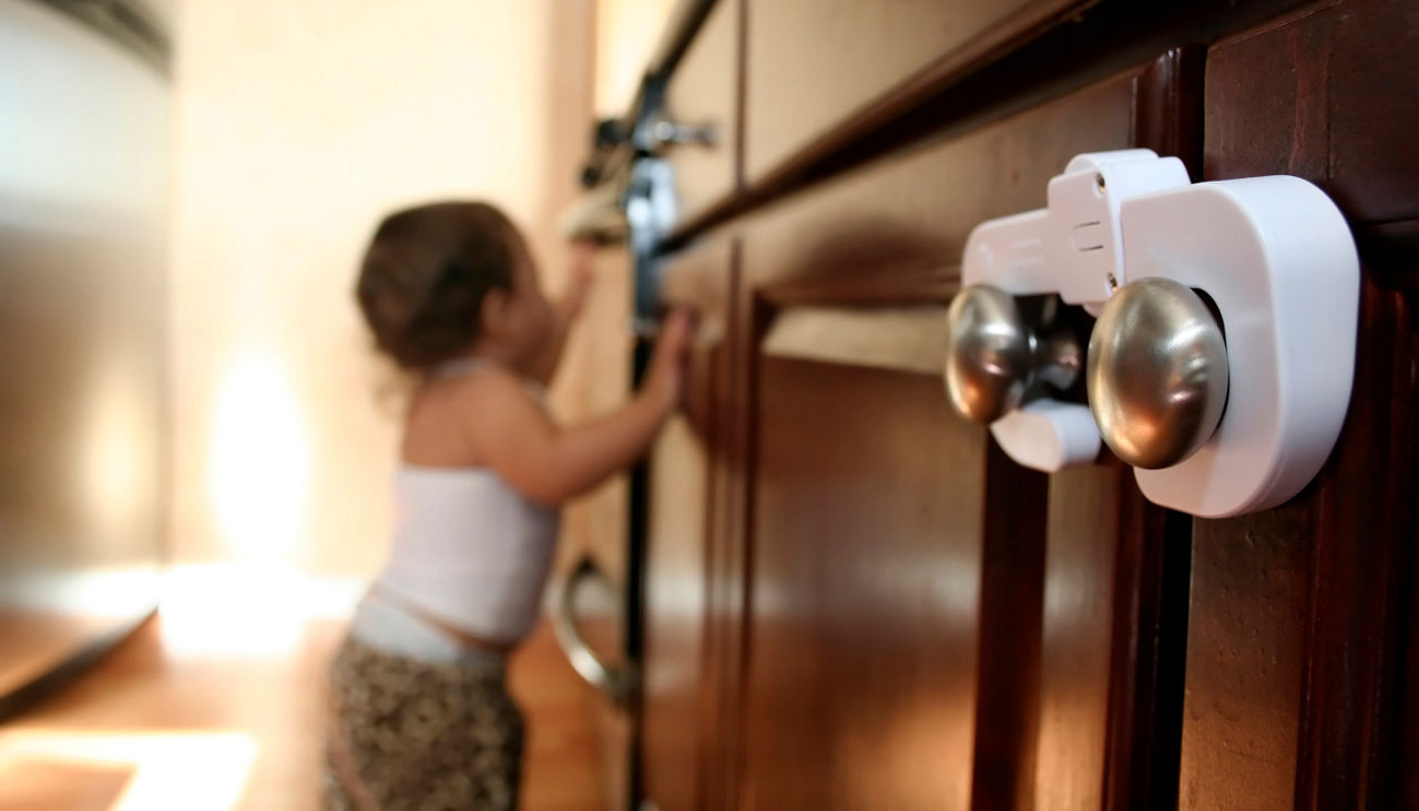 Close up on child proof cabinet latch and knob on far right