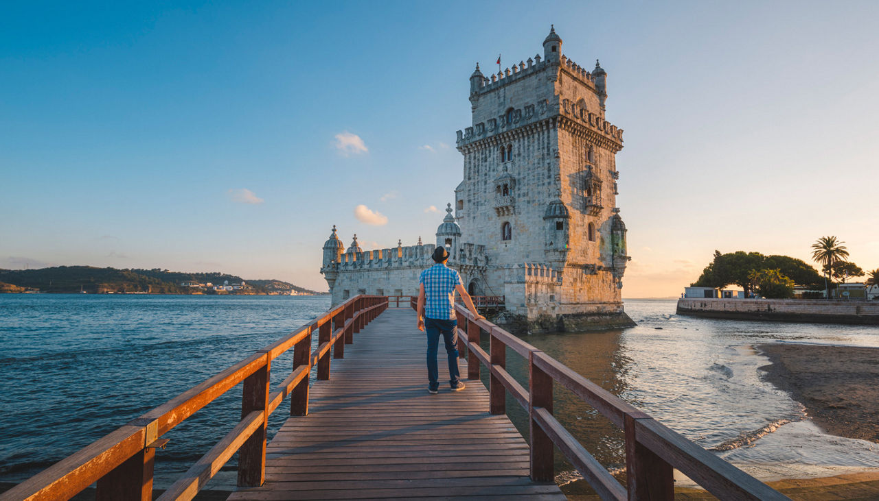 Tourist admiring the Belem Tower at sunset, Lisbon