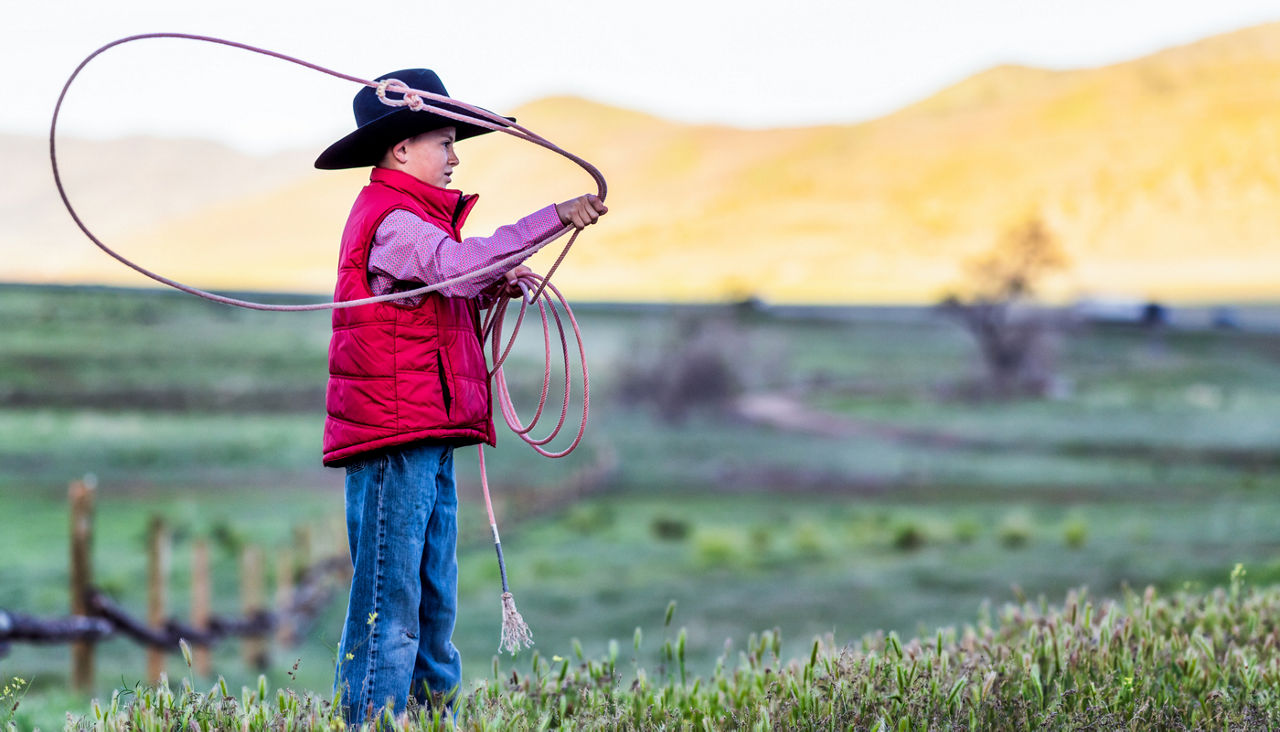 A young boy developing rope skills as he throws a lasso in Utah, USA.