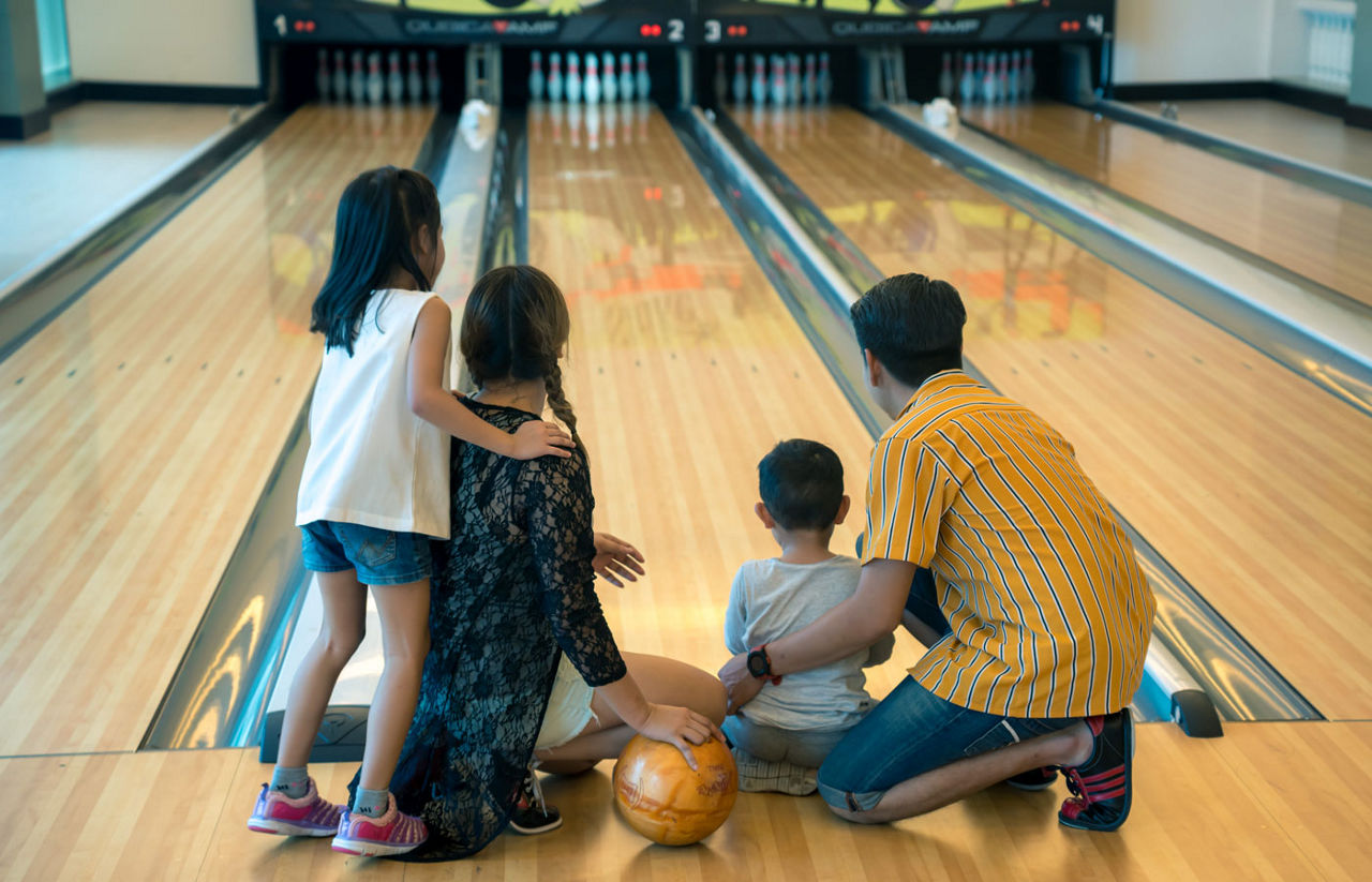 Young family having fun bowling