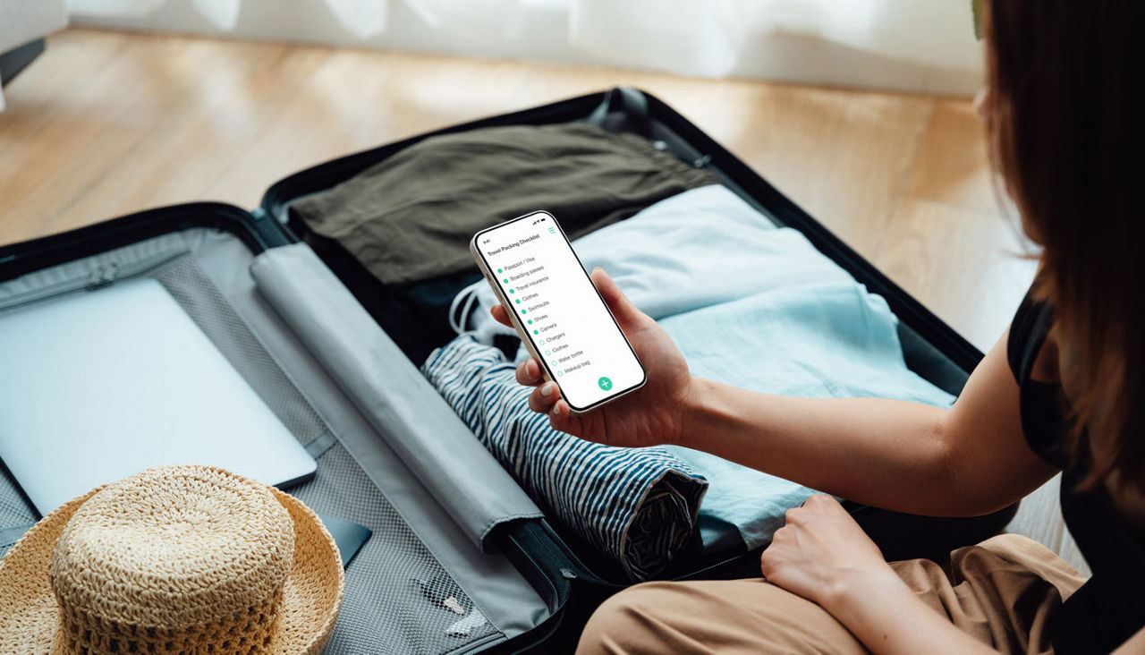 woman checking her phone while packing