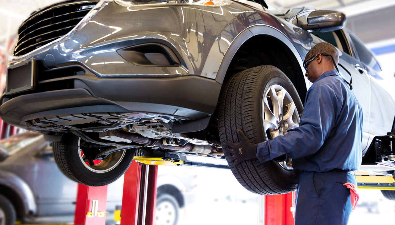 Service tech remove tire from vehicle on lift.