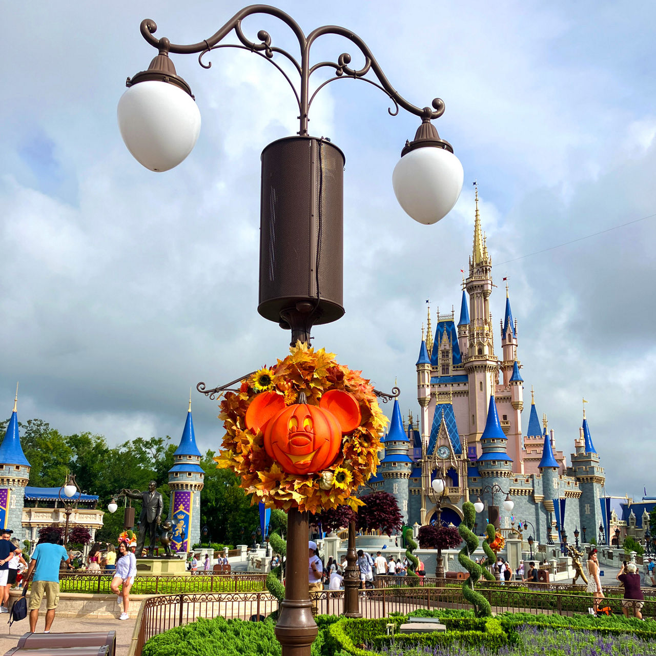 Disney's Halloween lamp post decorations with Cinderella's castle in background.