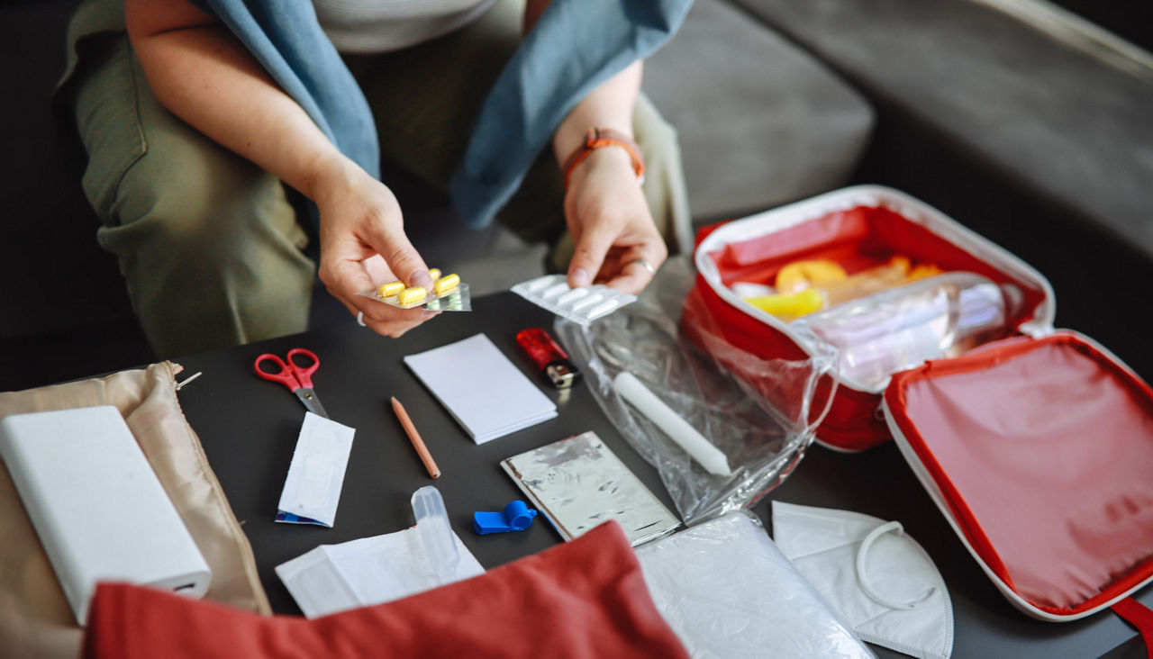 woman organizing medicine in preparation for essential supplies for emergencies