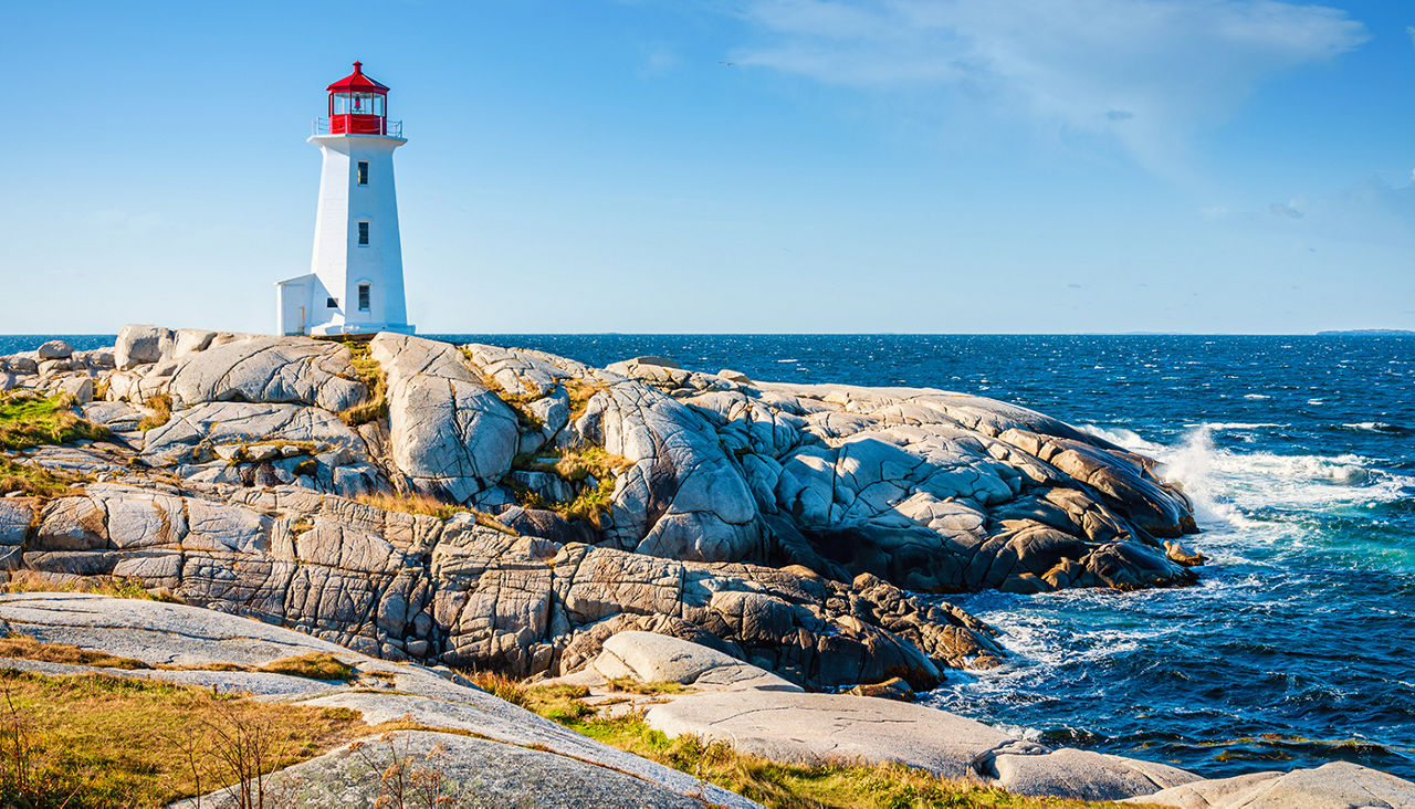 Peggy's Cove Lighthouse under blue summer sky. Peggy's Cove, Nova Scotia, Canada. Day and Night Series.