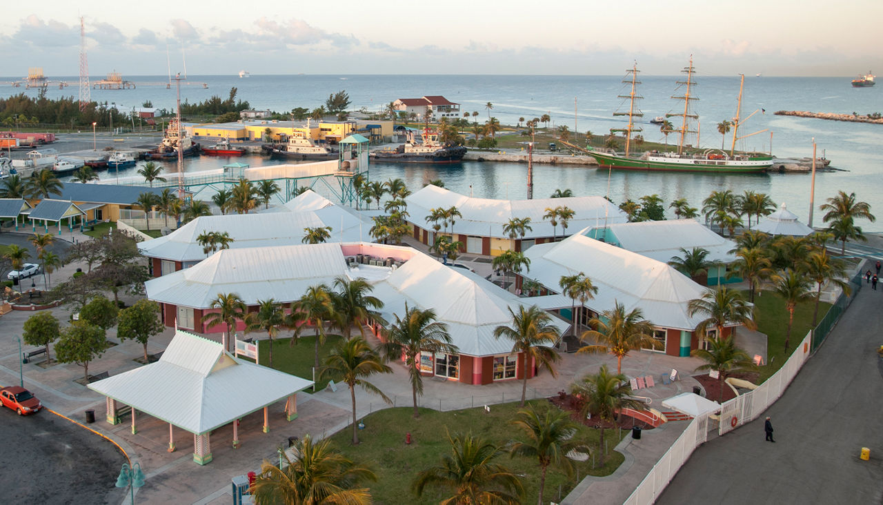 A resort by the water surrounded by palm trees.