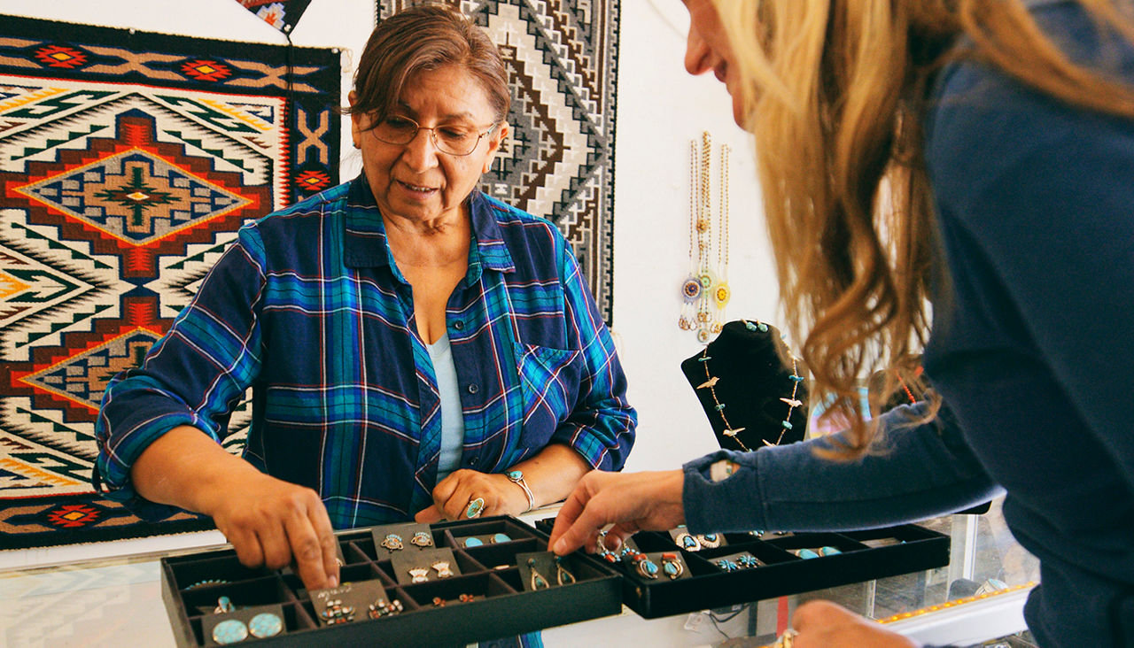 A female Indigenous Navajo small business owner at work in her jewelry shop.