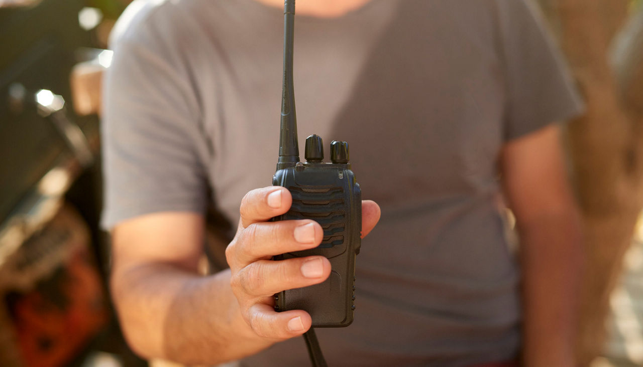 Man holding portable radio, preparing for emergency communication