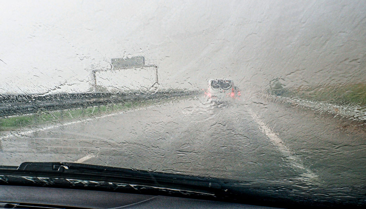 Driving very slowly on a highway in a heavy rainstorm