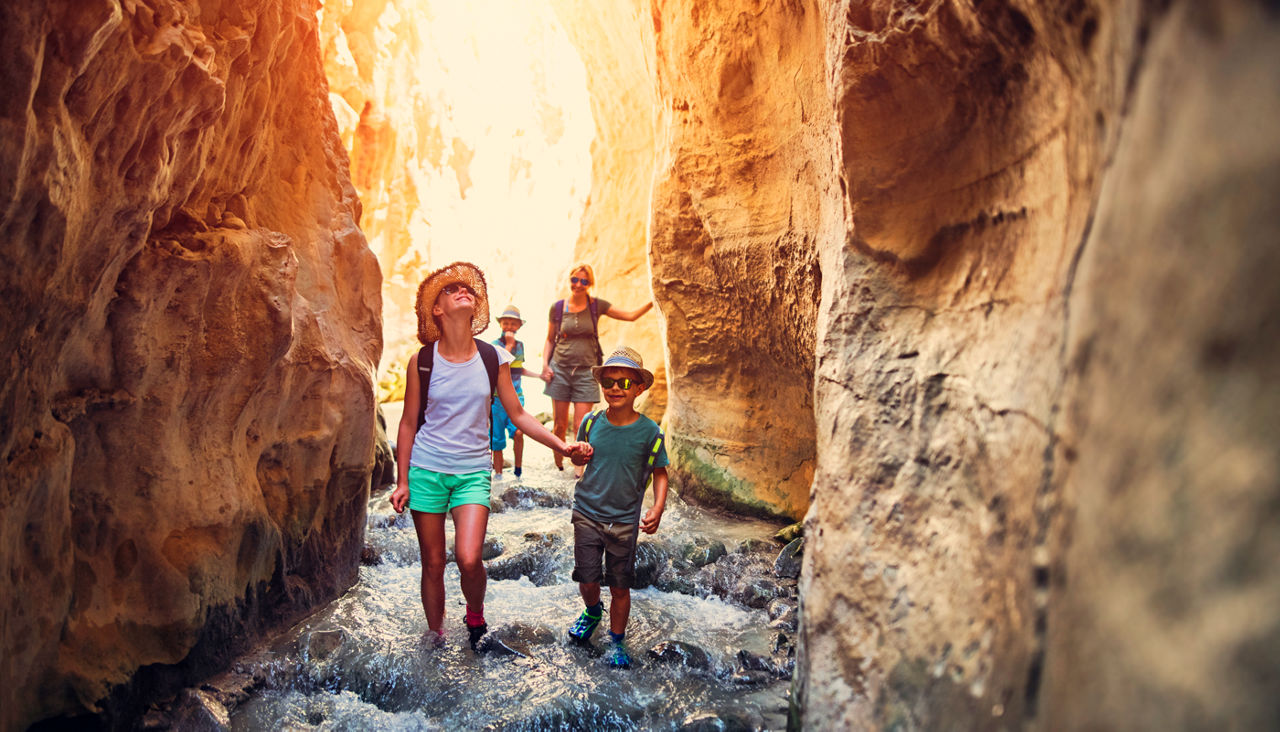 Mother and kids hiking through river Rio Chillar in Andalusia, Spain