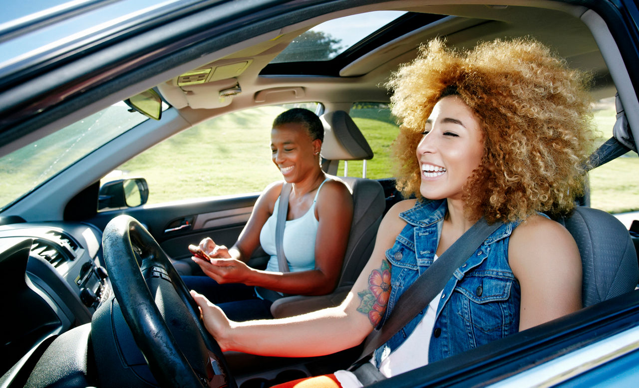 two women in a car driving on a trip