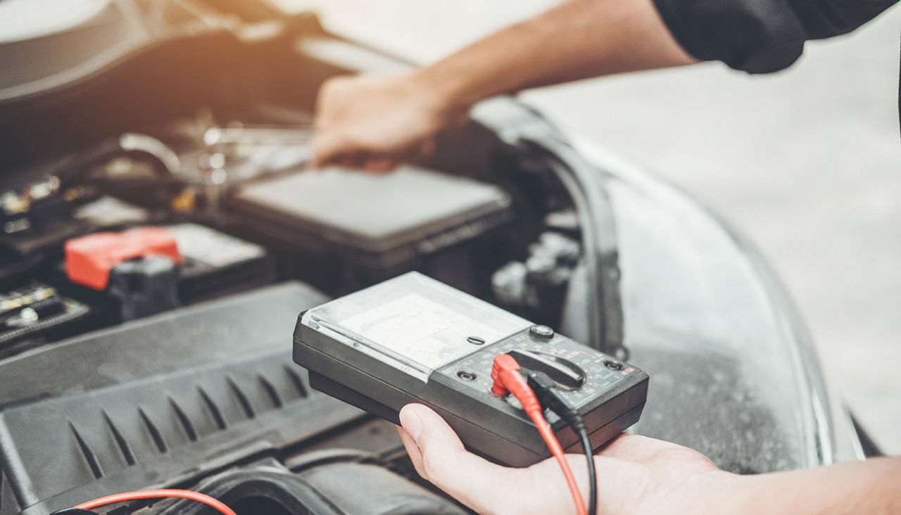 Auto mechanic working in garage Technician Hands of car mechanic working in auto repair Service and Maintenance check car battery.