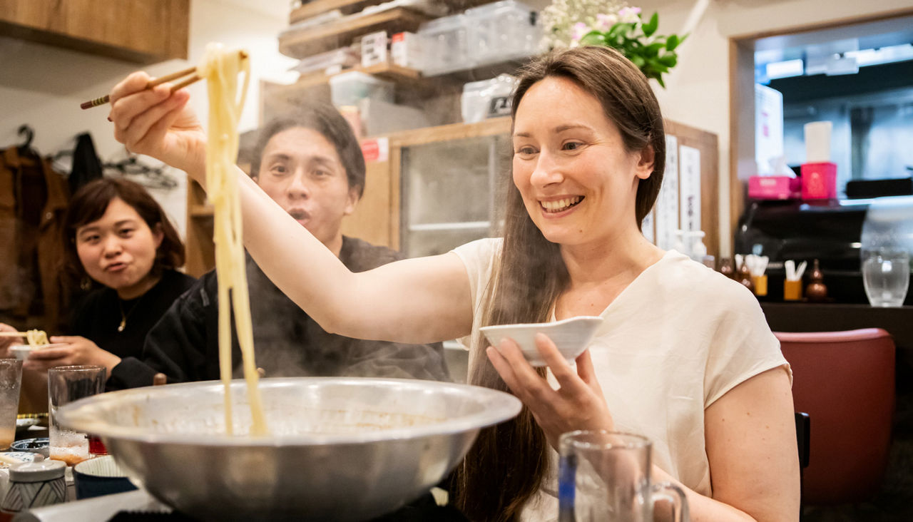 Tourists from overseas try eating udon at a Japanese izakaya