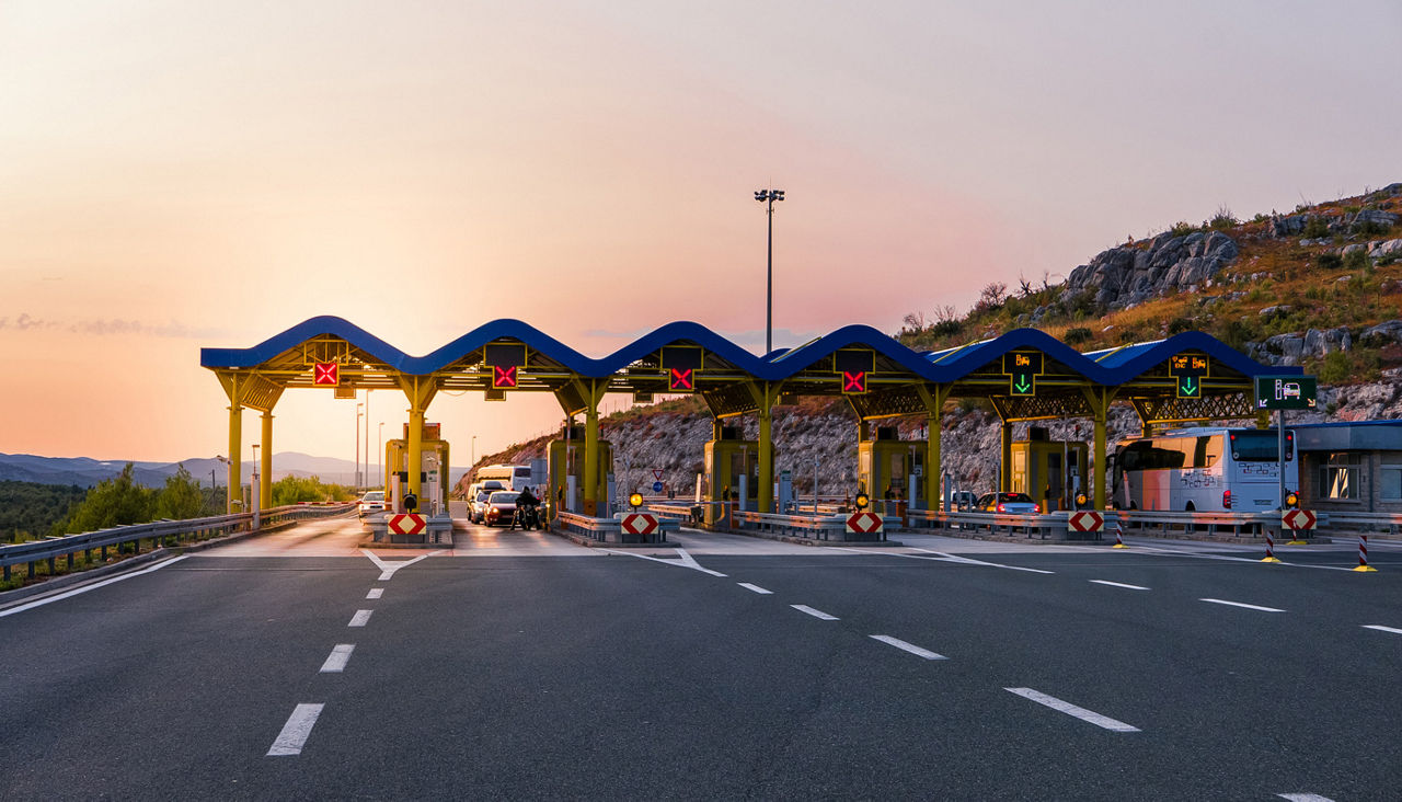 Cars passing through the toll gate on the motorway, vivid travel background